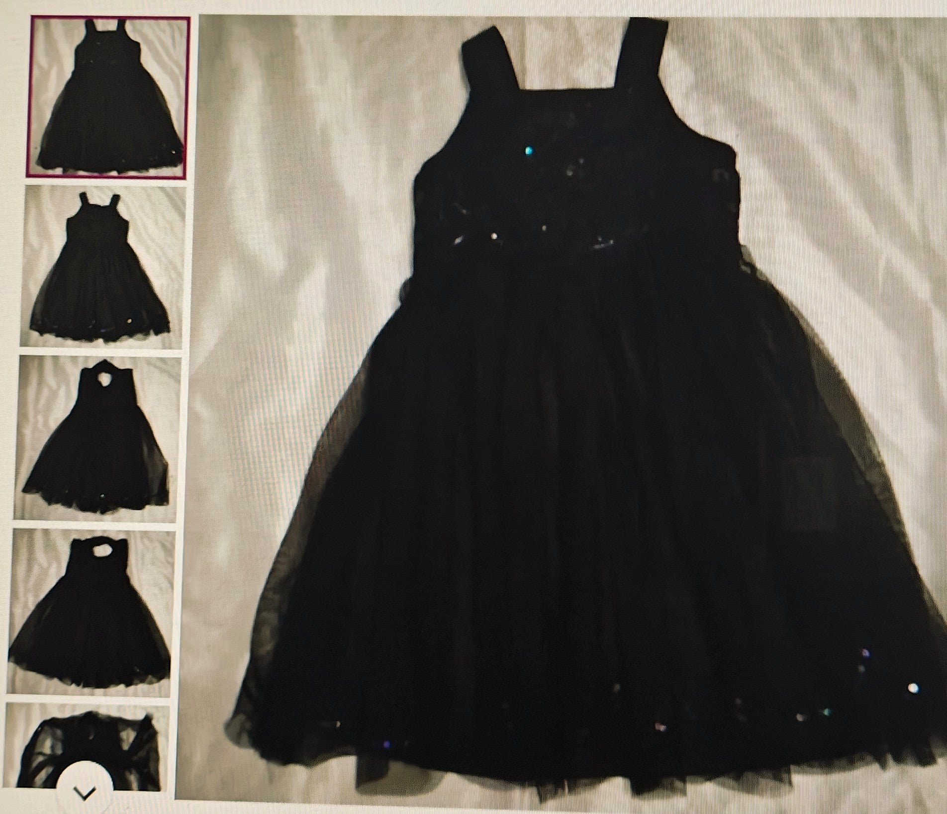 Black dress with sequin details on a light background