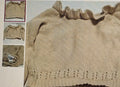 Beige knitted sweater with ruffled collar on a textured background
