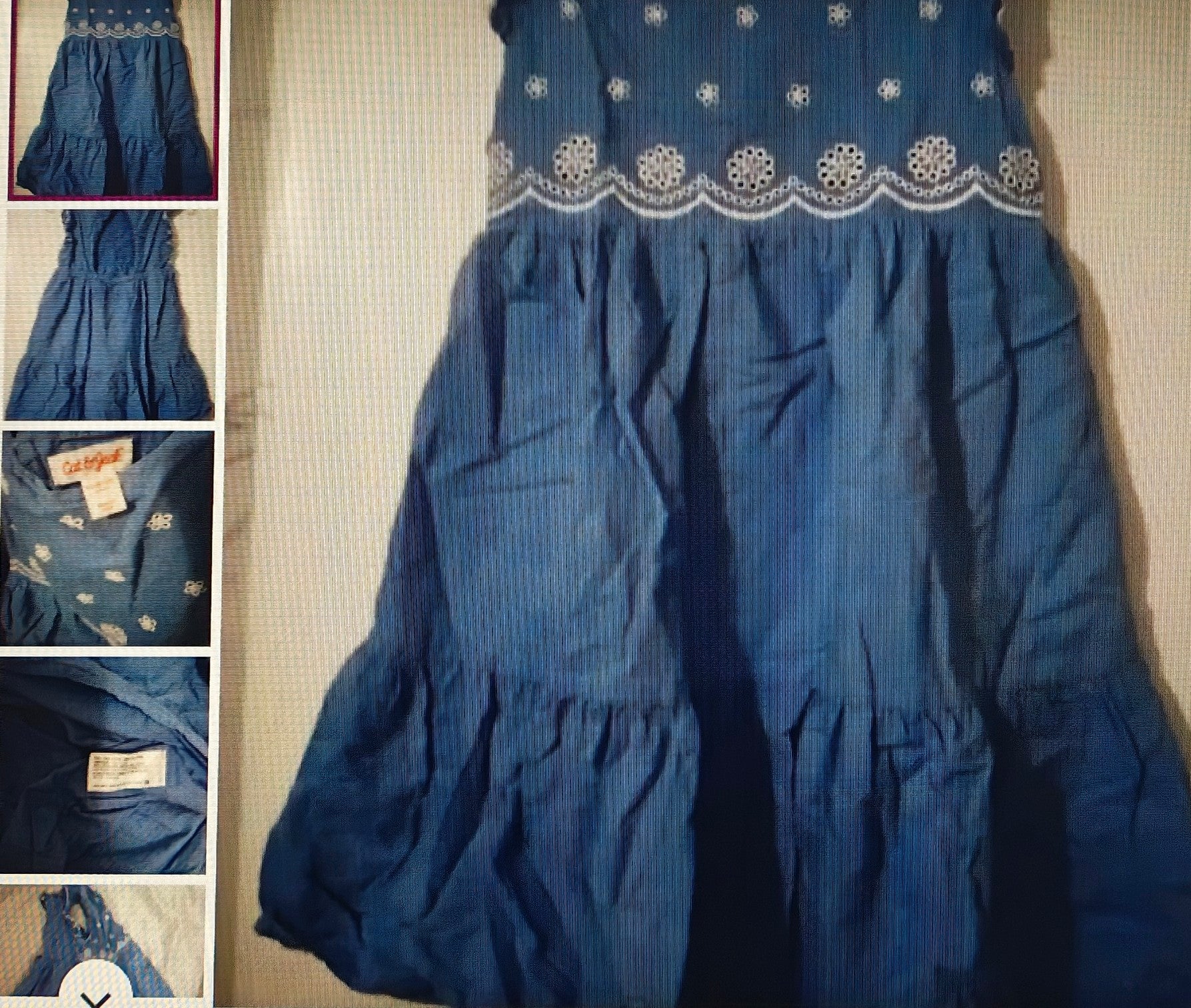 Blue dress with white embroidery on a textured surface