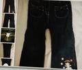 Black pants with bow details on a textured surface