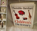 Thorndike-Barnhart Children's Dictionary with illustrations on a textured surface