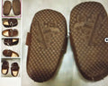 Brown shoes with detailed sole design on a light background