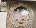 Decorative plate with a winter scene design on a textured surface.