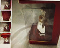 Small figurine in a decorative box with visible brand name
