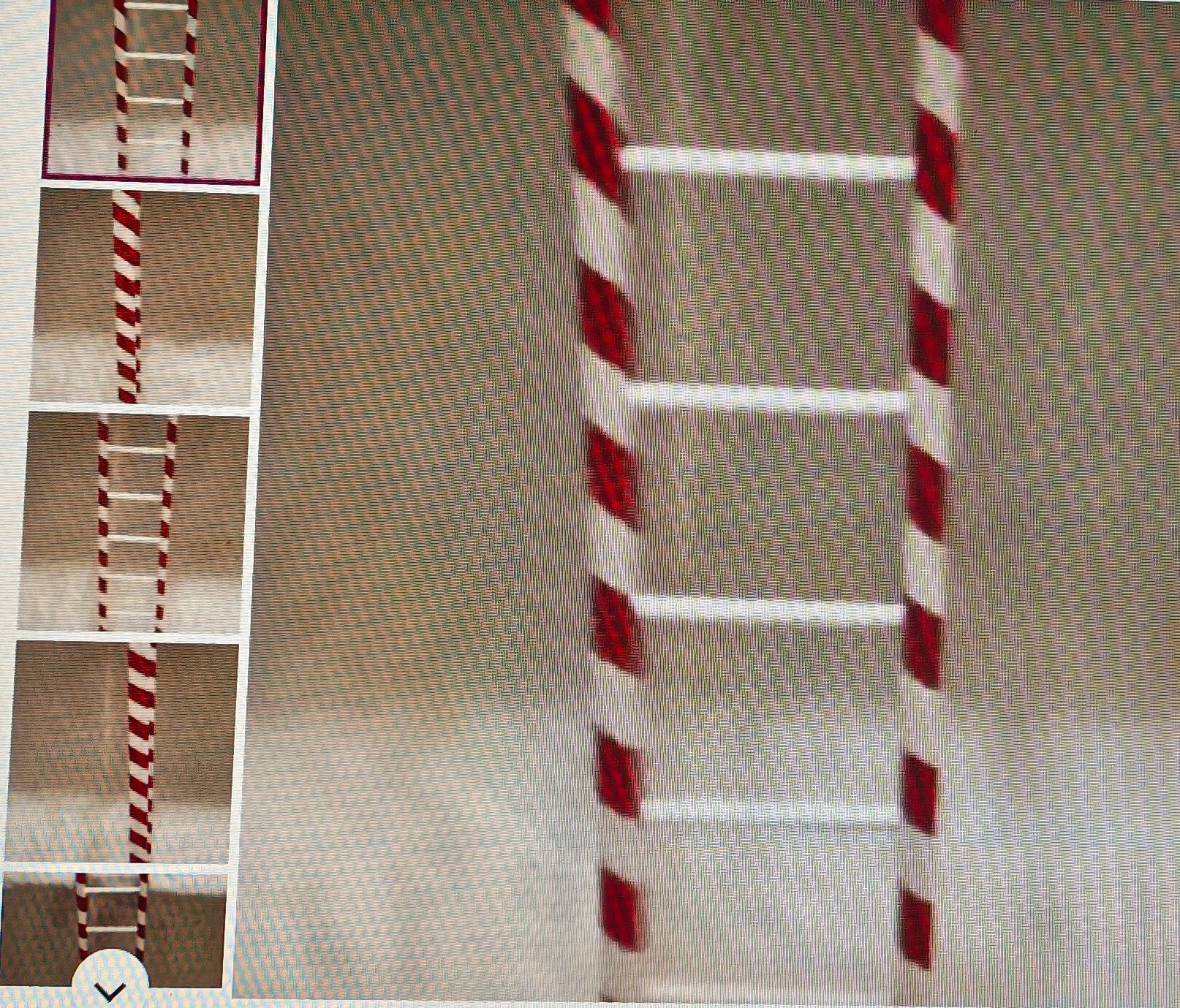 Red and white striped ladder on a textured surface