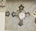 Decorative cross with floral patterns on a textured fabric background