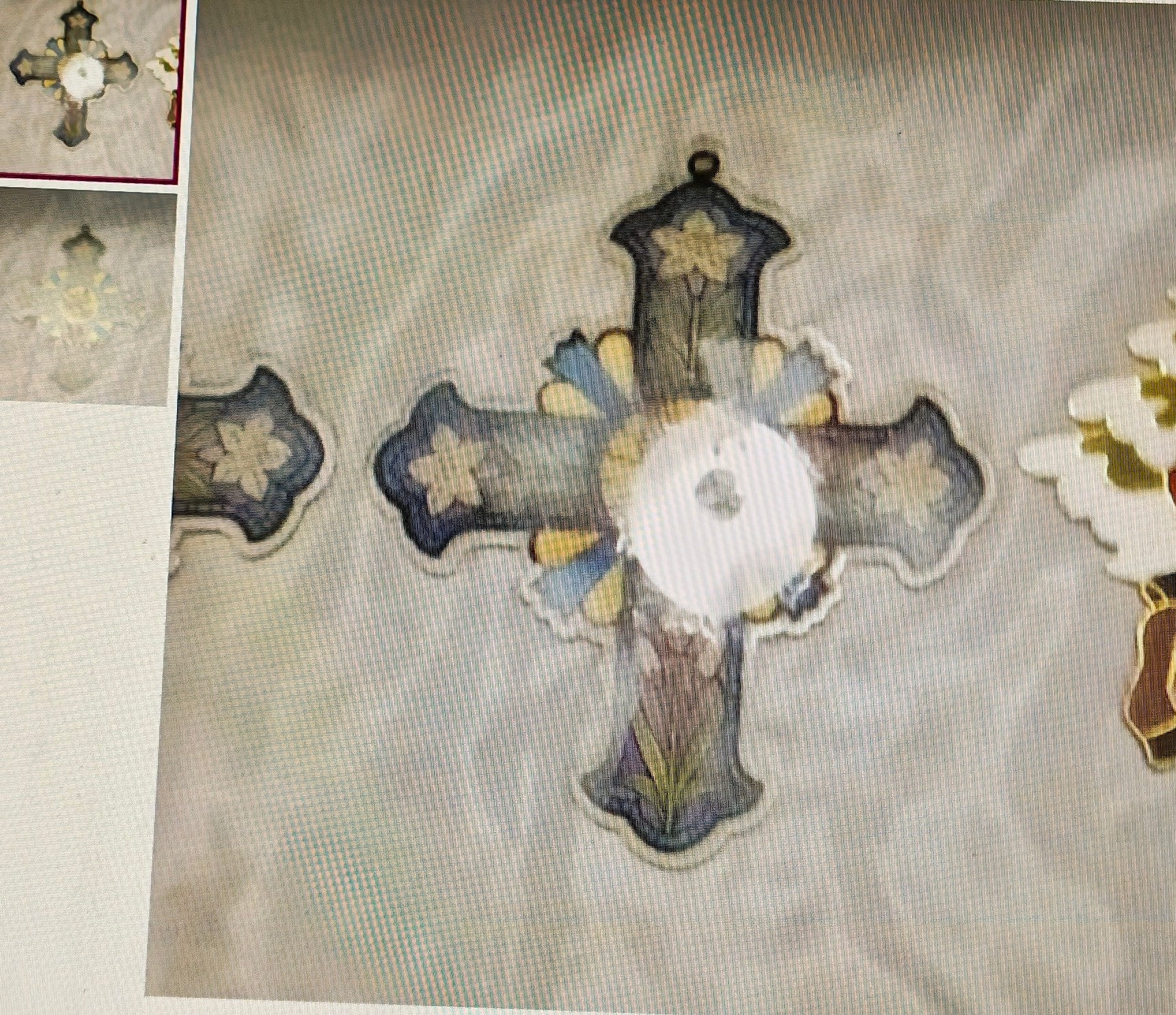 Decorative cross with floral patterns on a textured fabric background