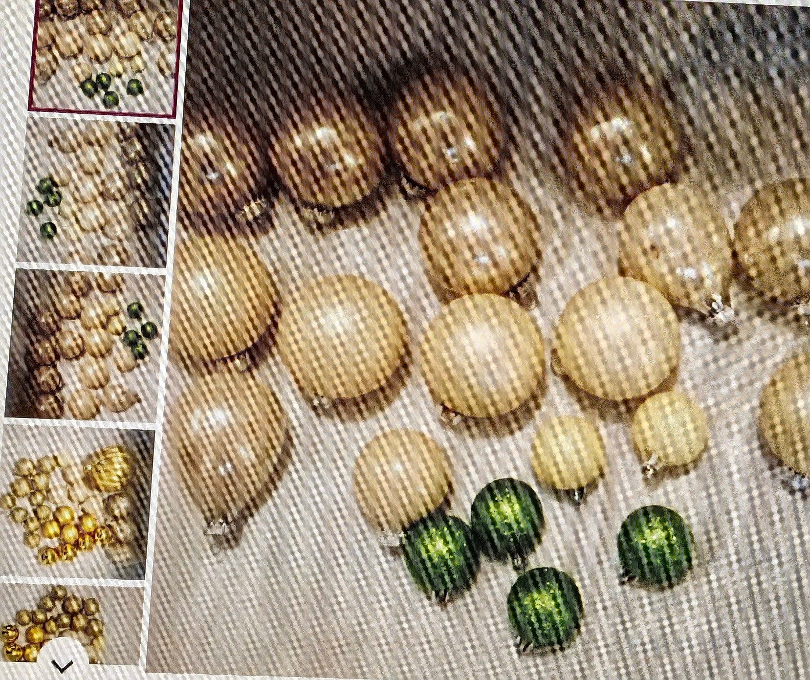 Collection of gold, beige, and green Christmas ornaments on a light surface.