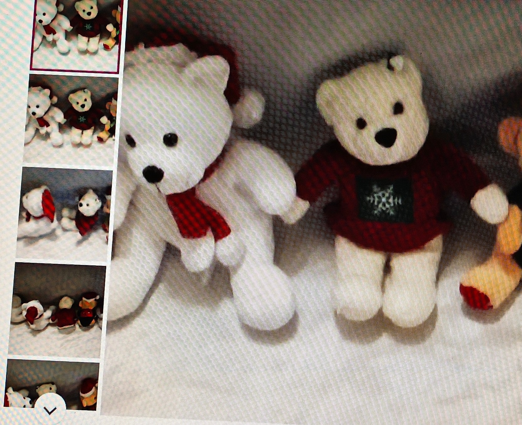 Two teddy bears, one white with a red scarf and the other brown with a sweater, on a textured surface.