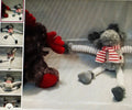 Two sock dolls, one with a red nose and the other with a striped scarf, on a textured surface.