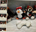 Collection of plush toys including a penguin and tiger on a textured surface.