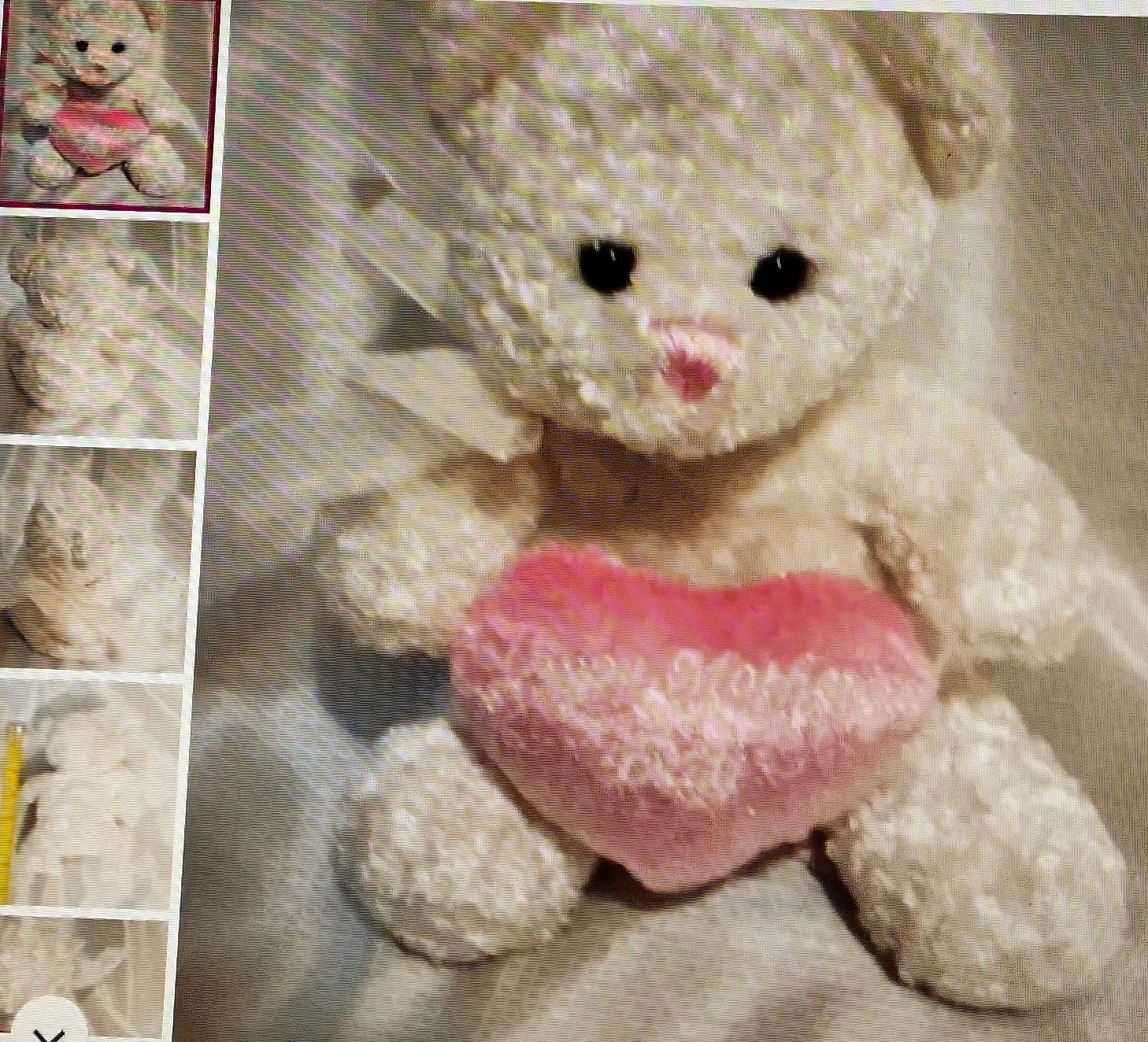 White teddy bear with a pink heart on a textured surface