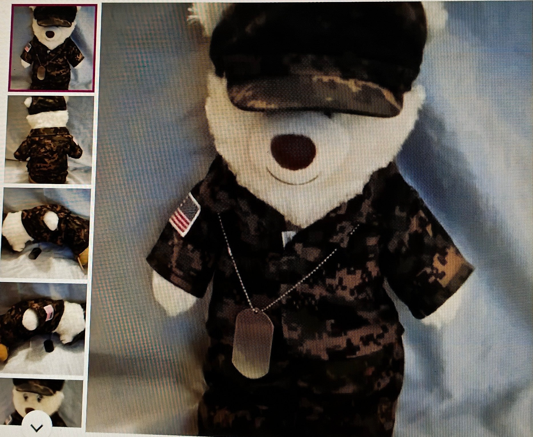 Stuffed bear in military uniform with an American flag patch and dog tag, on a textured gray background.