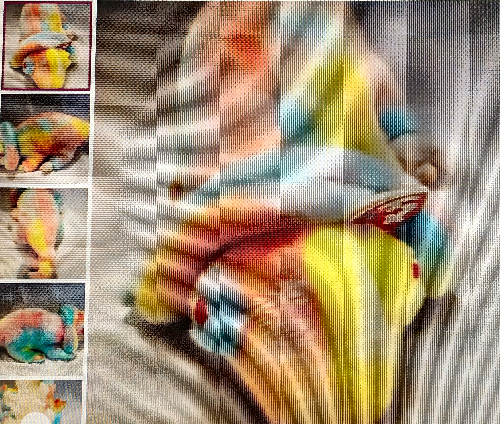 Colorful plush toy resembling a cartoon character on a textured surface.