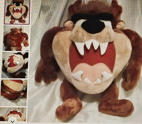 Plush toy resembling a cartoon character with a large mouth and teeth on a white background.