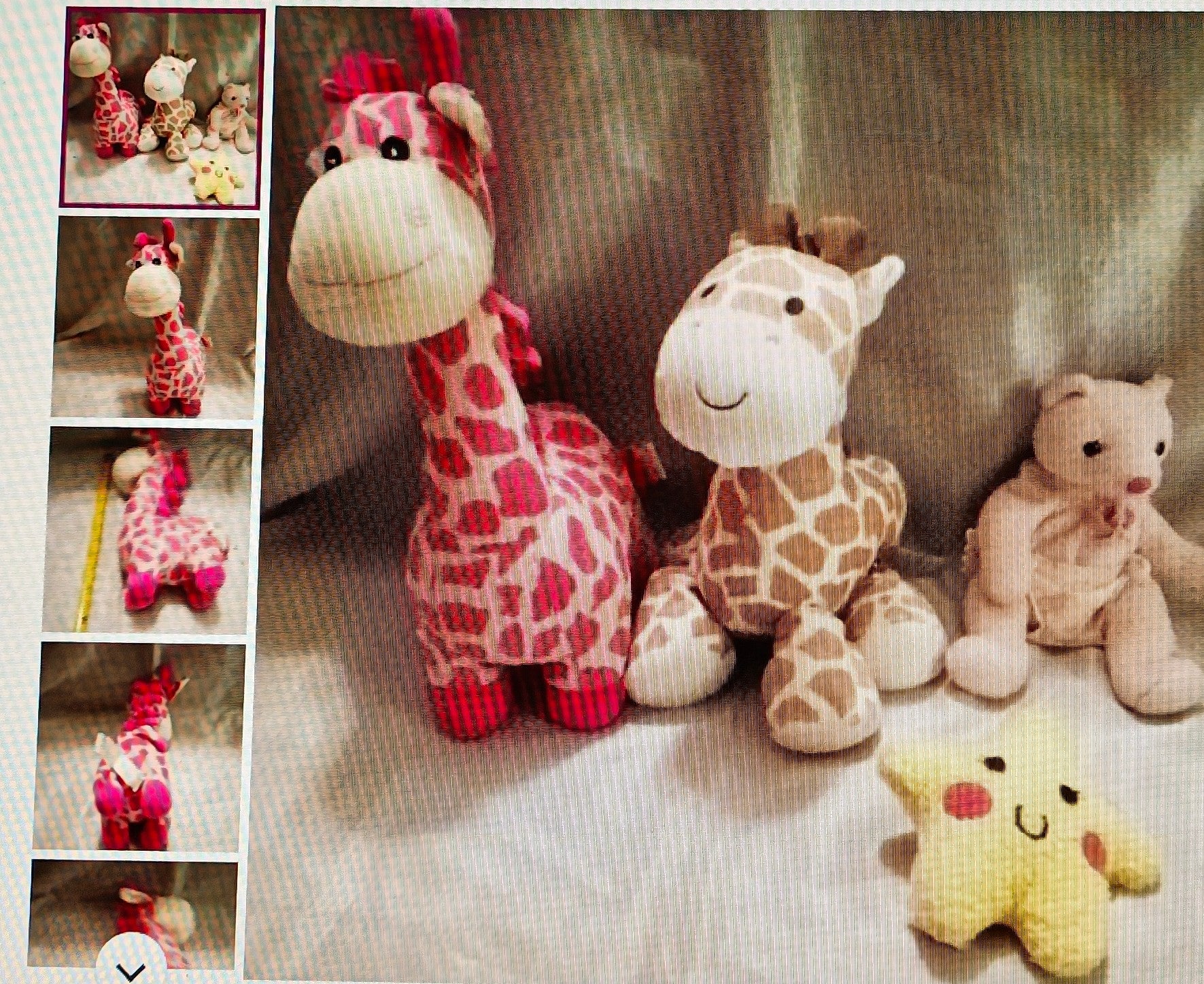 Collection of stuffed animals including giraffes and a bear on a textured surface.