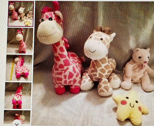 Collection of stuffed animals including giraffes and a bear on a textured surface.