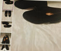 Black shoes on a textured surface with a small mirror reflection.