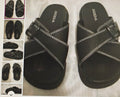 Black sandals with white stitching on a light background