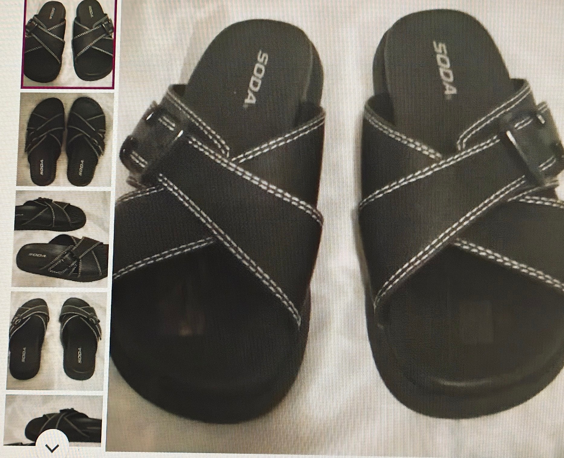 Black sandals with white stitching on a light background