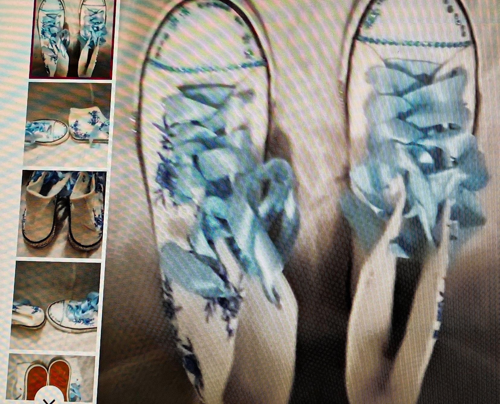 Pair of flip-flops with blue floral design on a metallic surface