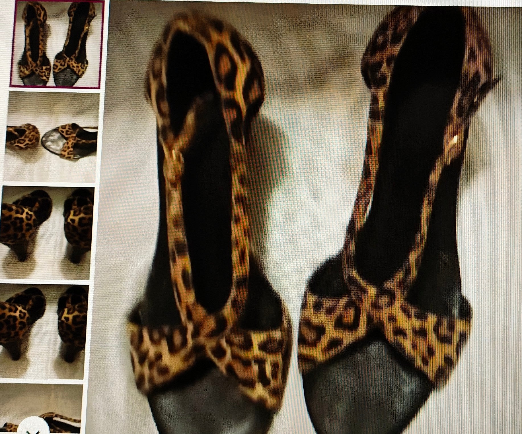 Pair of black shoes with leopard print straps on a textured surface.