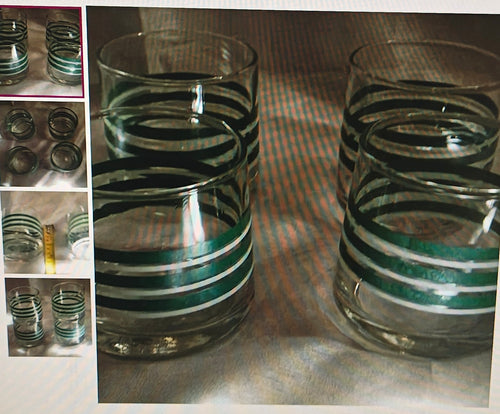 Set of glass tumblers with black and green striped design on a metallic surface.