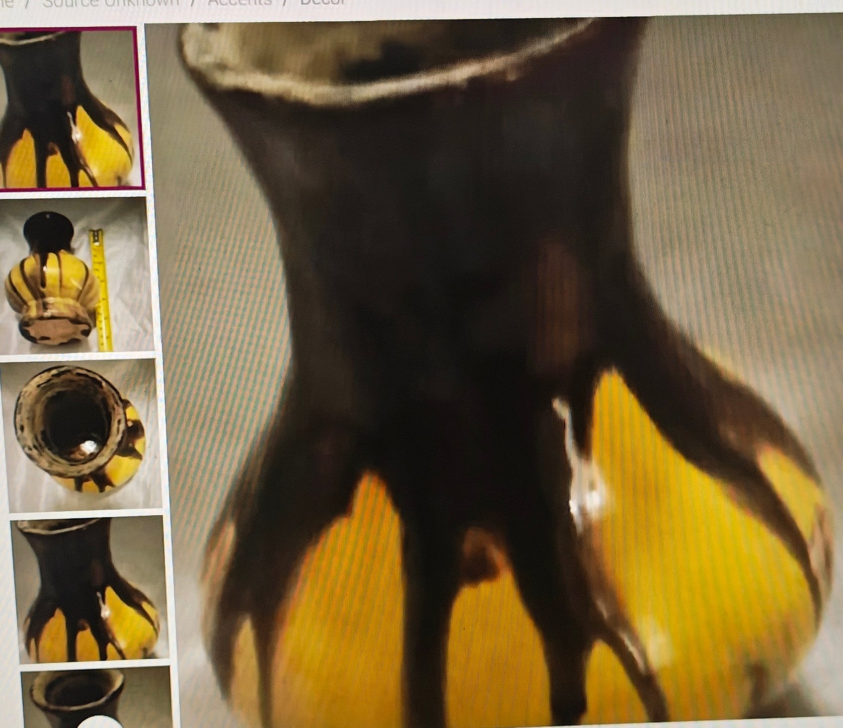 Close-up of a ceramic vase with a yellow base and black top, surrounded by other similar vases.