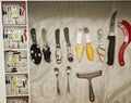 Collection of various knives and utensils on a textured surface