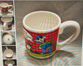 Colorful mug with cartoon design on a striped surface