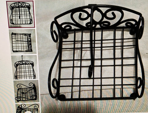 Decorative black metal grid stand with intricate designs on a textured surface.