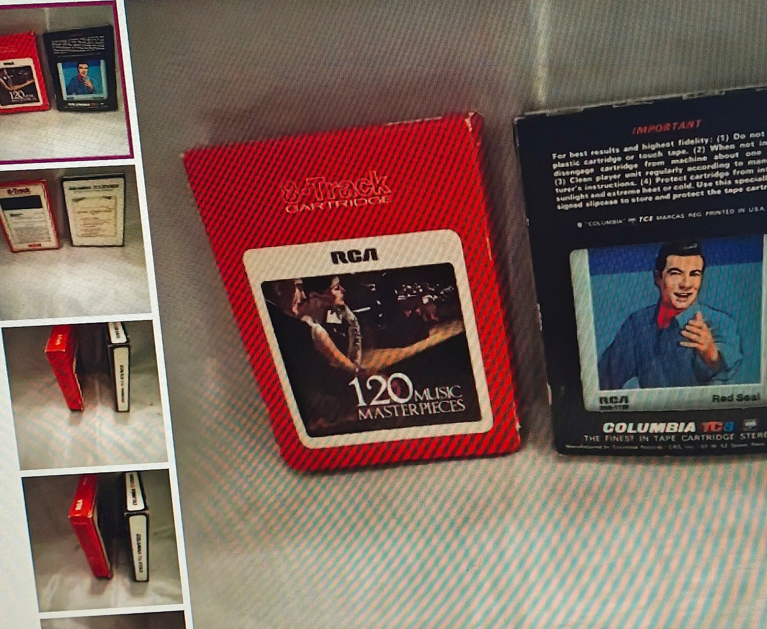 Red RCA cassette tape with a display of other cassette tapes on a gray surface.