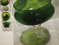 Green glass object with a textured surface on a white background