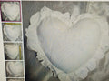 Heart-shaped decorative item with lace trim on a textured surface