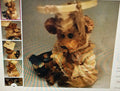Stuffed animal toy with a dress and hat on a textured surface