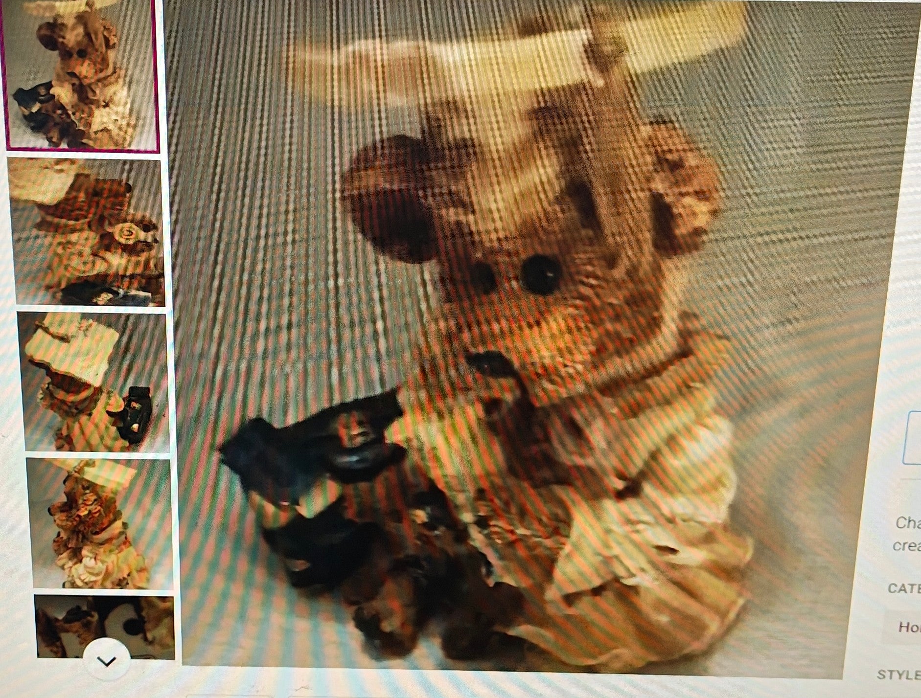 Stuffed animal toy with a dress and hat on a textured surface