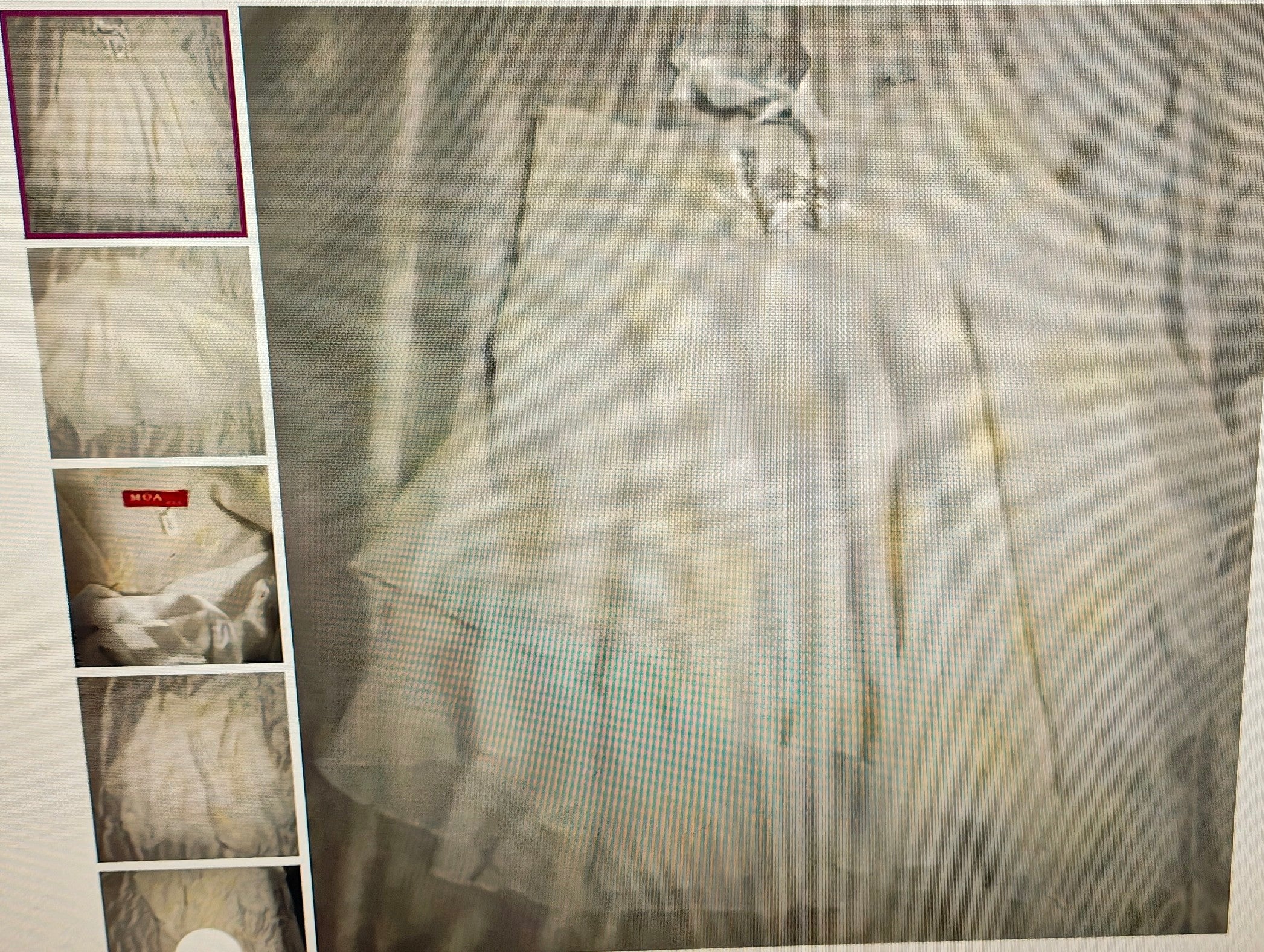 Light-colored dress with sheer overlay on a textured background
