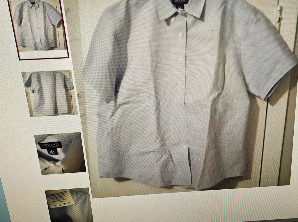 Light gray checkered shirt on a hanger with a small mirror reflection.