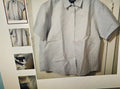 Light gray checkered shirt on a hanger with a small mirror reflection.