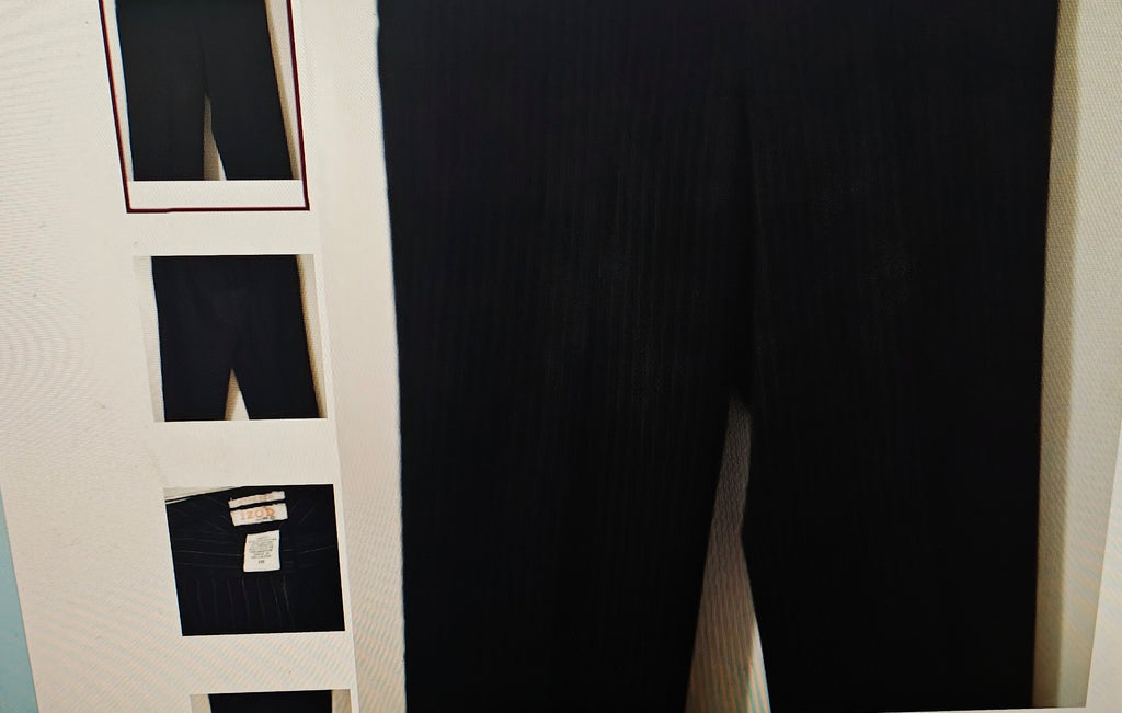 Black pants displayed on a rack with multiple pairs of pants.