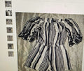 Black and white striped outfit on a textured fabric background