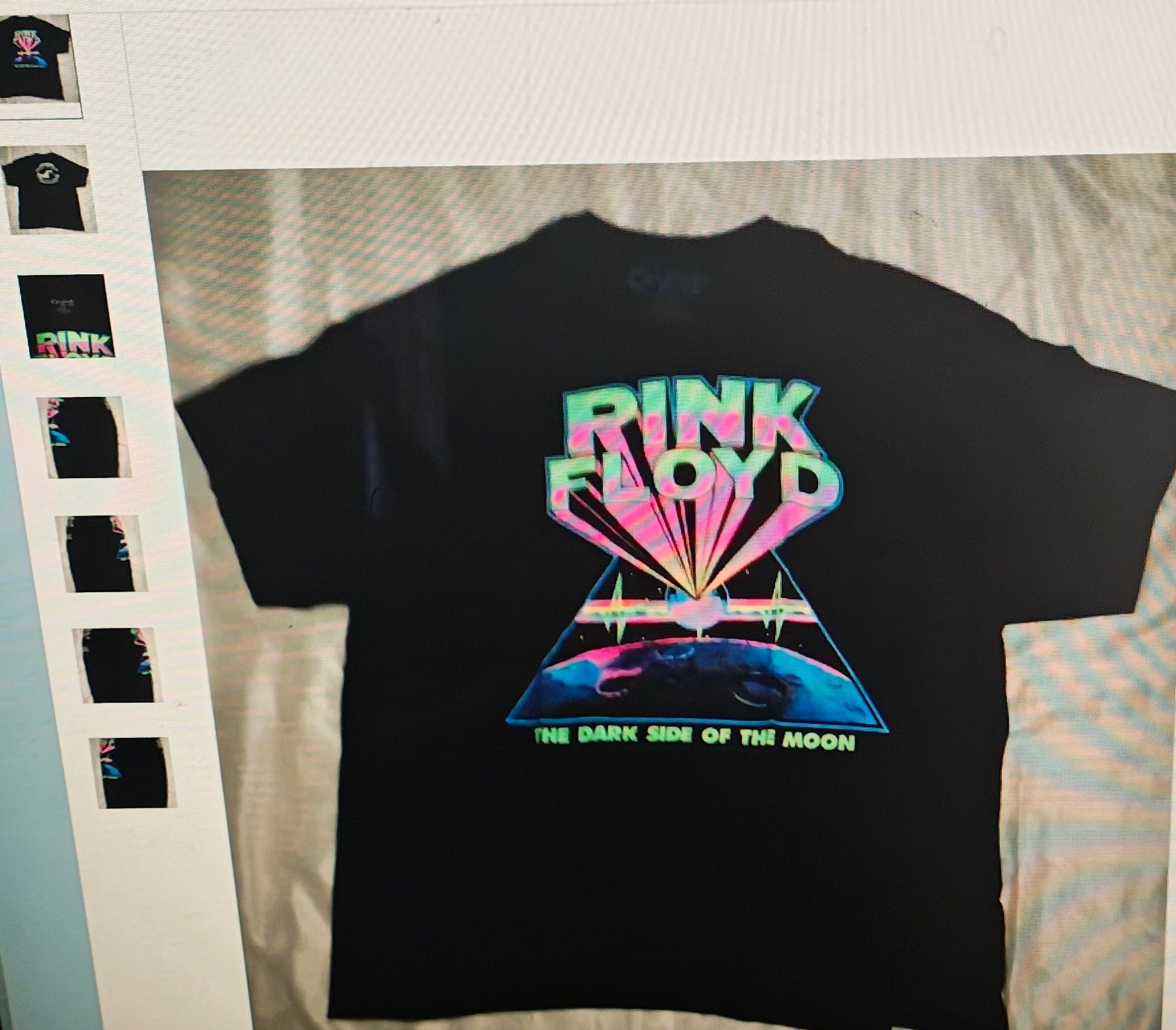Black t-shirt with Pink Floyd 'The Dark Side of the Moon' design on a light gray surface.