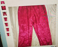 Red pants displayed on a hanger against a white background