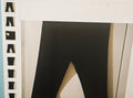 Black leggings hanging on a white rack with a neutral background