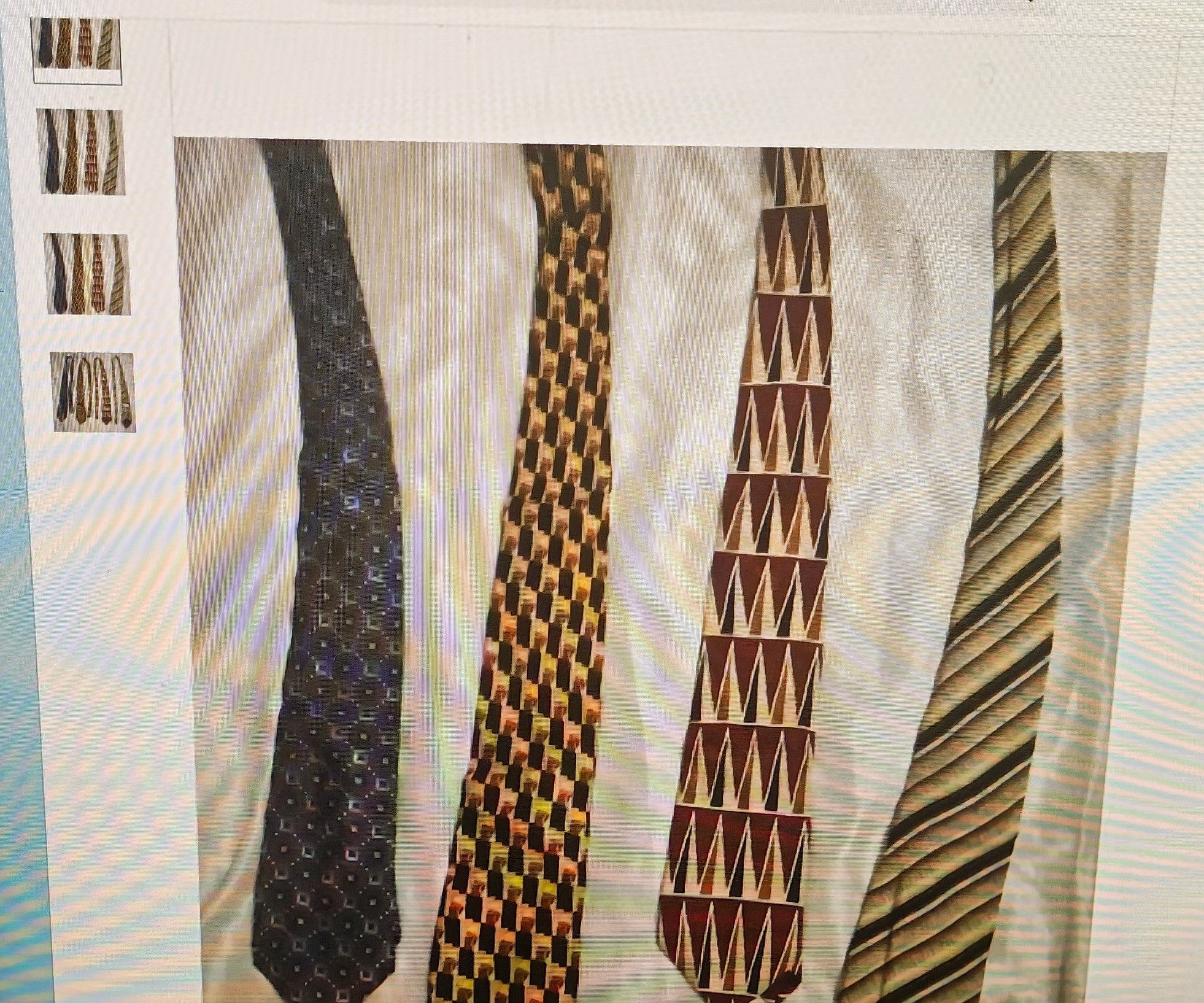 Four patterned ties displayed on a textured surface