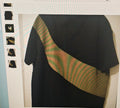 Black t-shirt with green and red striped sleeves on a white background