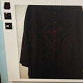 Black shirt on a hanger against a light blue wall with a textured pattern.
