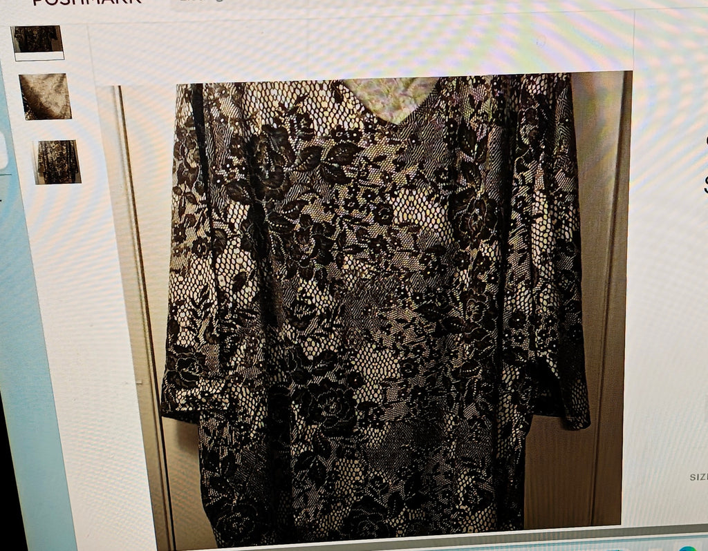 Black lace garment on a hanger against a white background