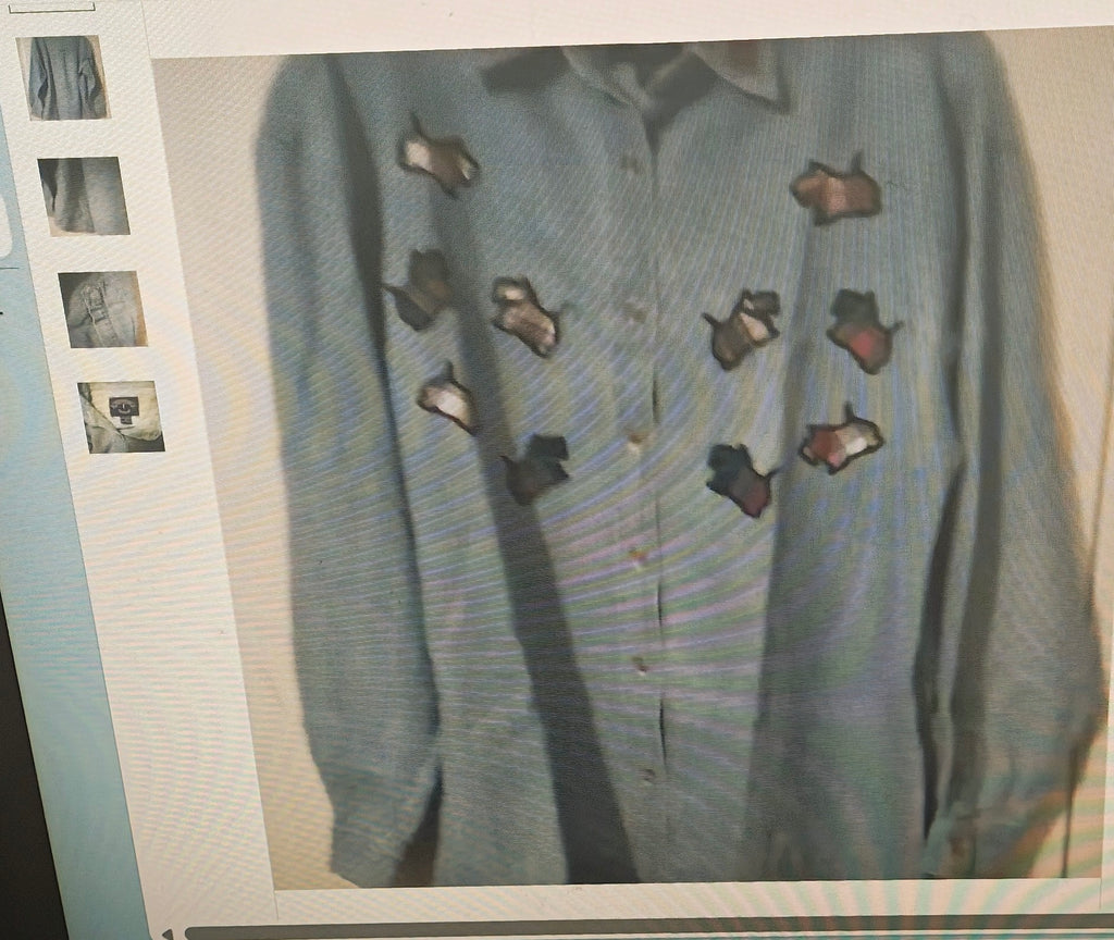 Light blue sweater with cut-out patterns on a textured surface