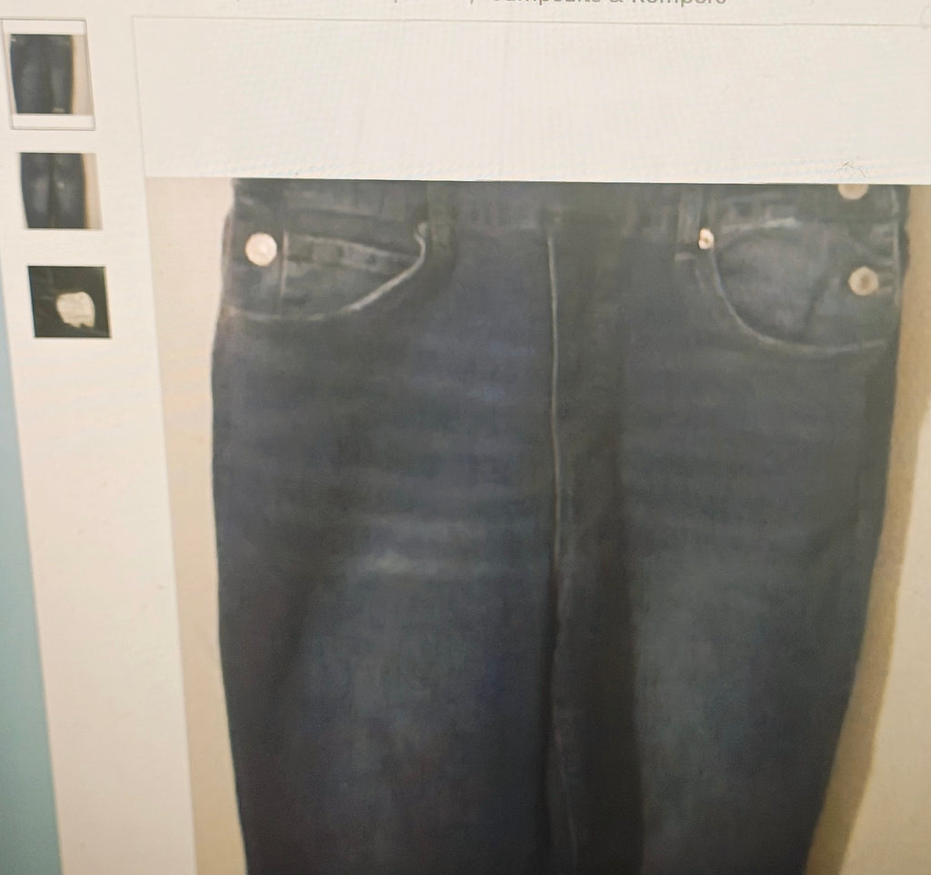 Pair of blue jeans displayed on a hanger against a neutral background
